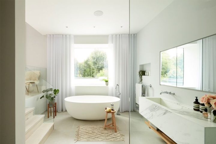 Large-bathroom-with-modern-freestanding-tub-and-marble-sink-window-curtains