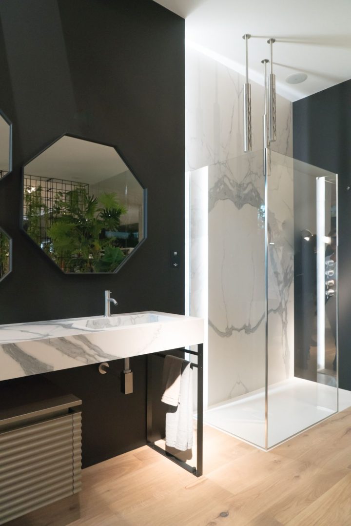 Walk-in-shower-featuring-marble-wall-and-chrome-frame