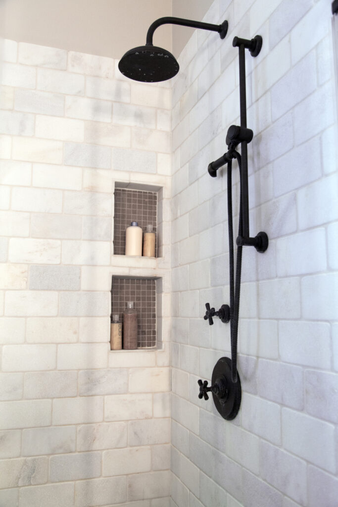 Black-shower-fixture-and-marble-tiles-683x1024-1