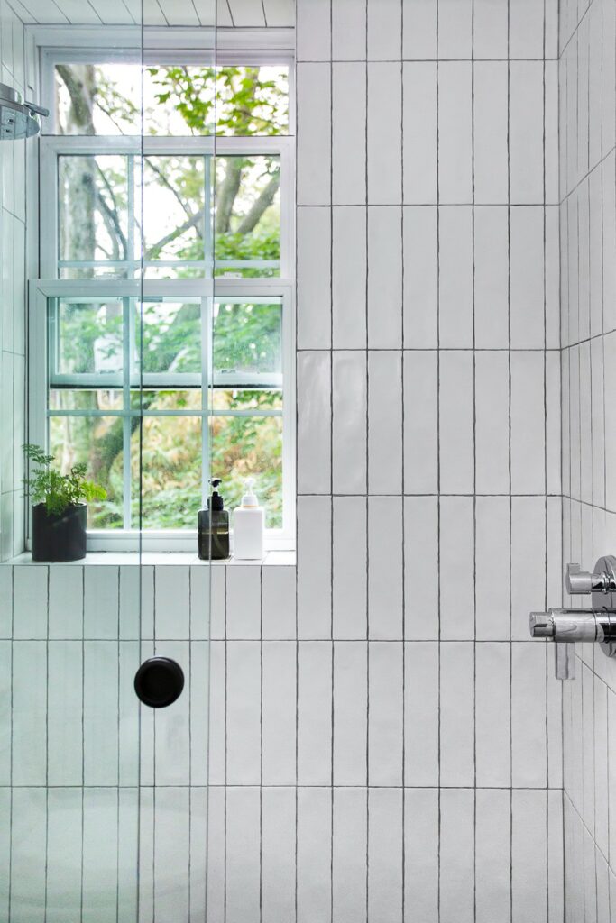 Glass-enclosed-shower-with-vertically-stacked-subway-tile-683x1024-1